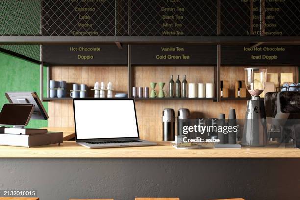 A portrait-oriented photo of a customer working on a sleek laptop at a glass table in Jelly Cafe.