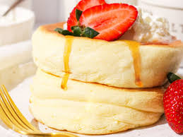 A stack of 'Jelly-Cloud' fluffy pancakes drizzled with a translucent pink syrup and topped with fresh raspberries and a dollop of whipped mascarpone.