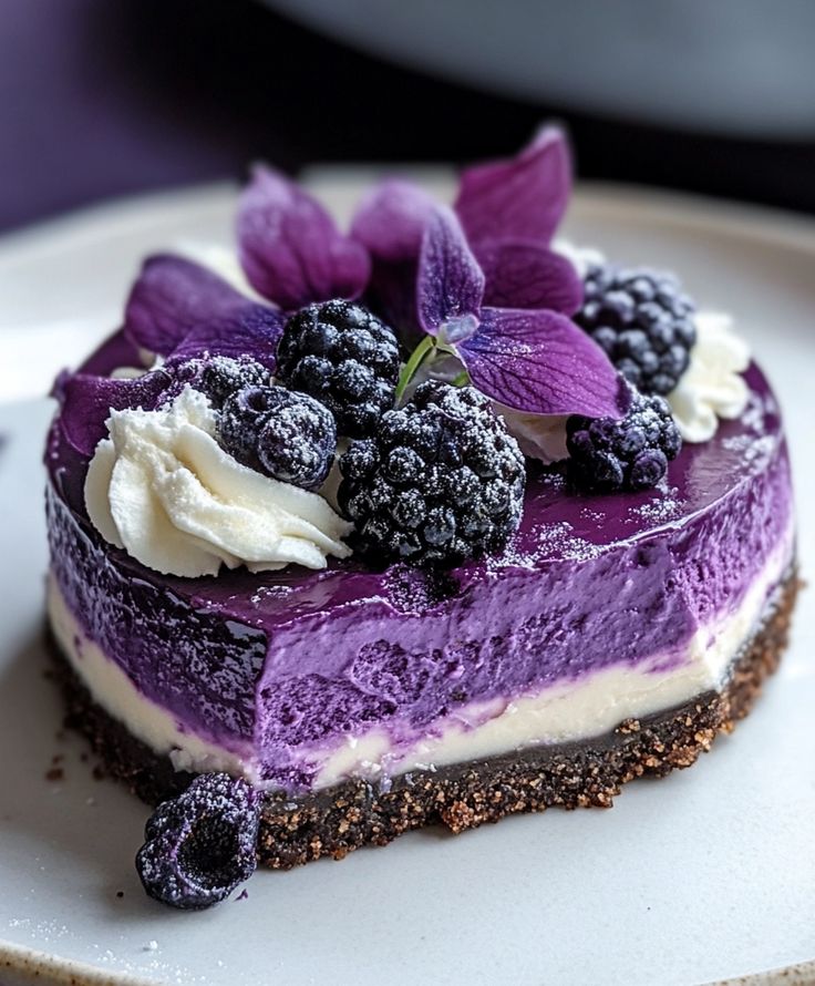 A close-up of a 'Violet Dream' pastry, a delicate lavender-colored tart topped with crystalized jelly drops and edible silver leaf.